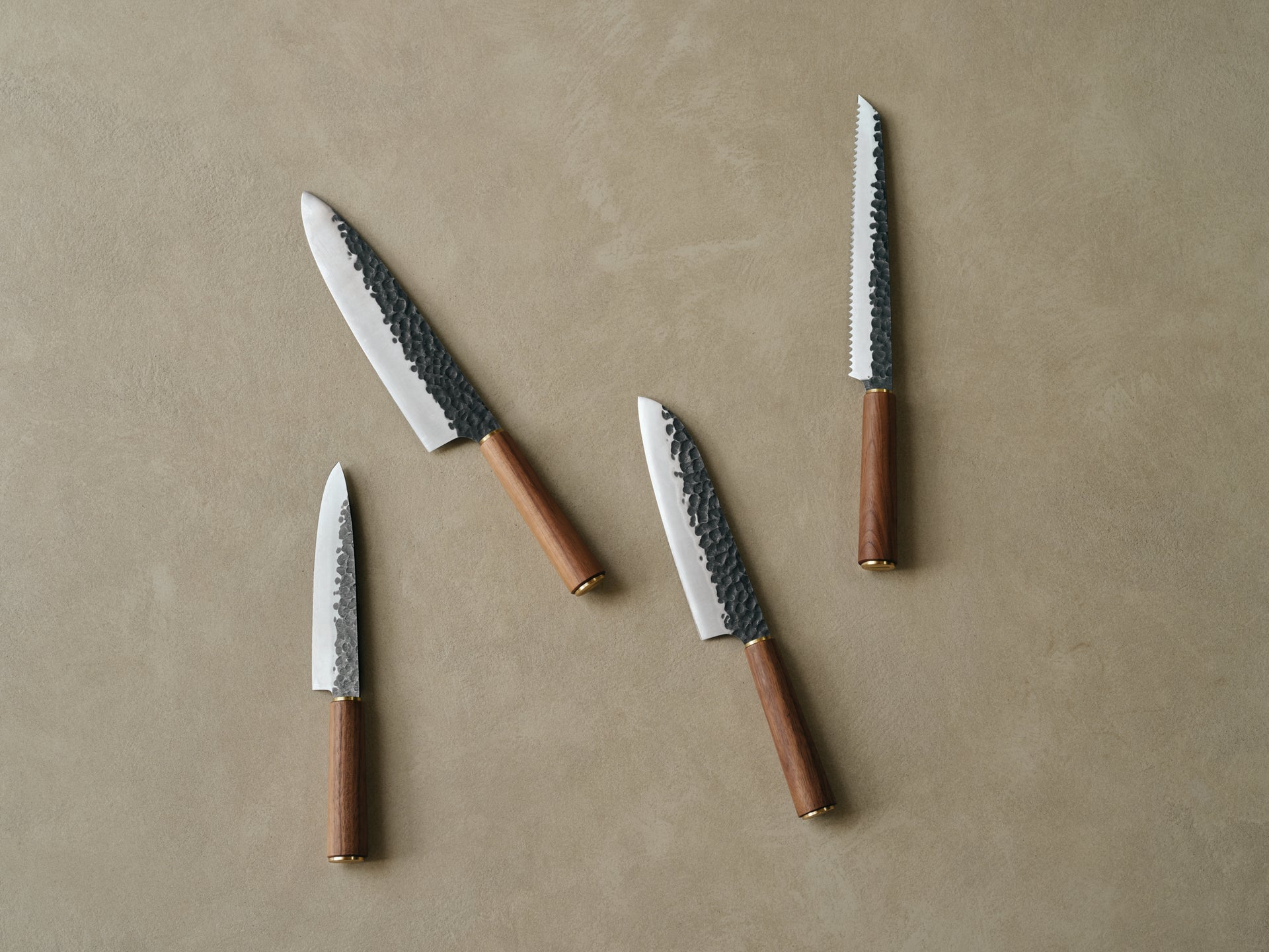 A set of Katto knives on a warm stone surface